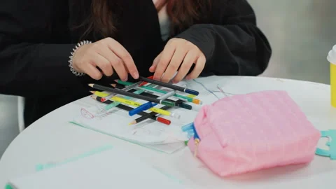 Student sorts vibrant writing tools. Young person arranges pens and highlighters Stock Footage 328148992
