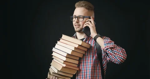 Student With Stack Of Books Talking on Phone Video stock 122938410