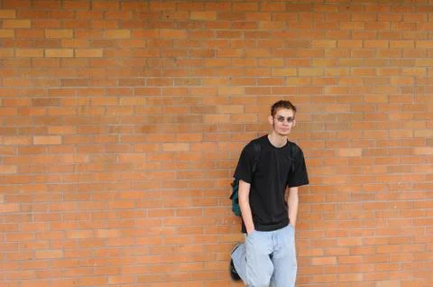 Student standing in front of brick wall Stock Photos