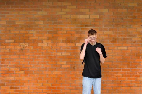 Student standing in front of brick wall Stock Photos