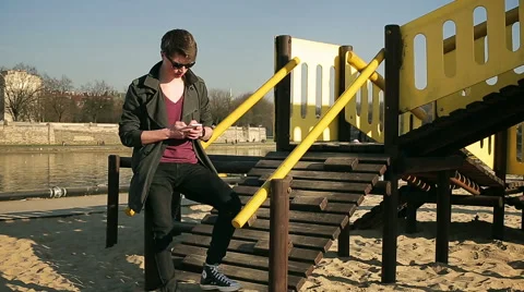 Student standing on playground and texting on smartphone Stock-Footage 48222472