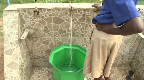 STUDENT STANDS NEXT TO BUCKET BEING FILLED WITH WATER Stock Footage 60116199