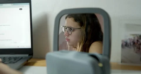 Student Stress Reflected: A young student stares into a small mirror. Stock Footage 336405422