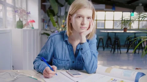 Student studies for exam or homework trying to concentrate with the mobile phone Stock Footage 103290952