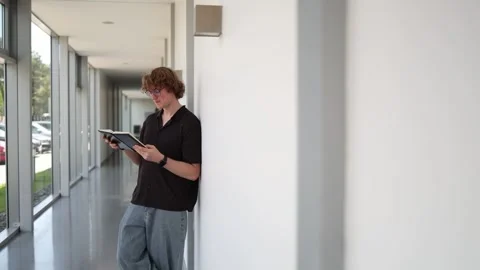 Student studies from notebook in hallway Stock Footage 338277040