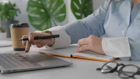 A student studies online using a computer to access materials and lessons. Woman Stock Footage 256709297