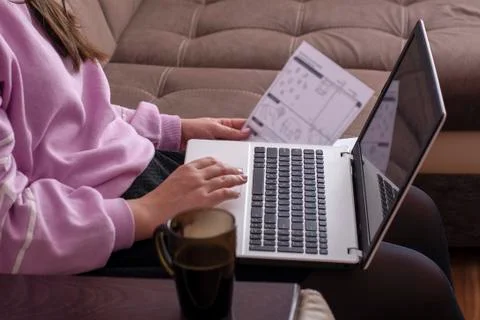 Student study sitting on the couch and studying the material on the laptop Stock Photos