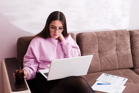 Student study sitting on the couch and studying the material on the laptop Stock Photos