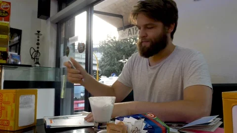 Student studying in a cafe drinking coffee and reciting words. Video stock 120298367