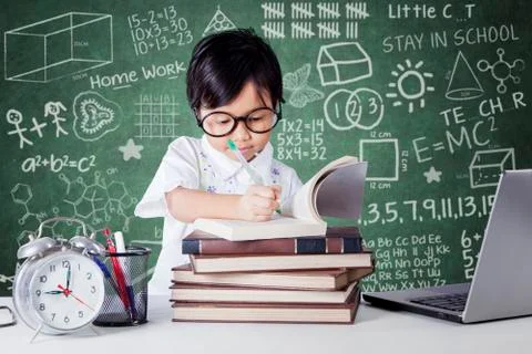 Student studying in class with clock and laptop Stock Photos