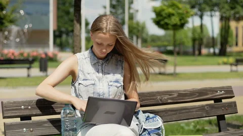 Student studying on laptop and drinking water while sitting on the bench 스톡 동영상 67369403