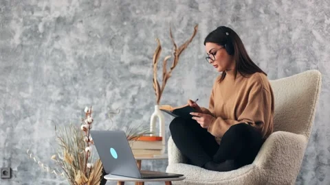 Student studying online course classes at home writing down notes in note book Stock Footage 234598724