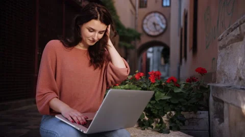 A student studying outdoors, freelancer working on decorative stone of city Stock-Footage 220099437