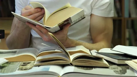 Student at a table with a huge amount of books 스톡 동영상 155962913