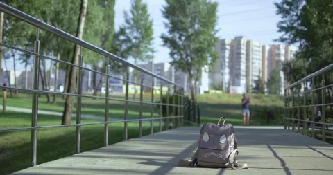 A student takes a backpack with textbooks left on the bridge Stock Footage 115079791