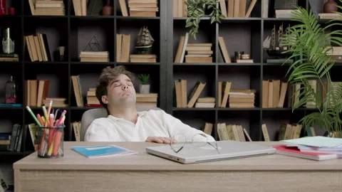 Student takes a break from studying and rests his eyes and hands. Tired boy Stock Footage 316090787