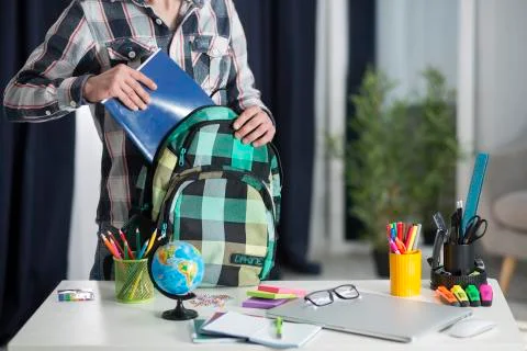 The student takes a notebook from his backpack 写真素材
