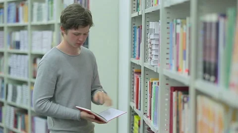 Student Taking Book from Bookshelf in Library Stock Footage 63045175