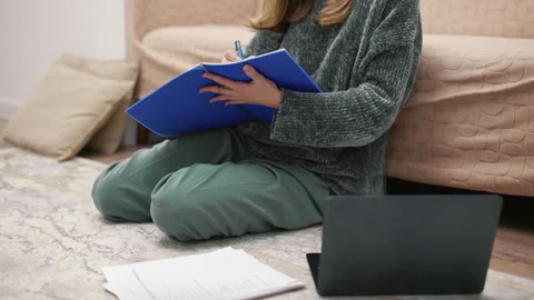 Student taking notes during online lecture at home Stockbeeldmateriaal 340931677