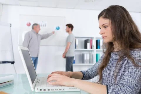 Student taking notes with laptop in class in university Stock Photos