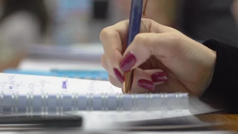 A student is taking notes in a lecture at the university close up Stock Footage 303346797