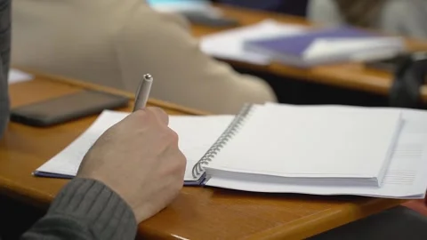 A student is taking notes in a lecture at the university close up Stock Footage 303346801