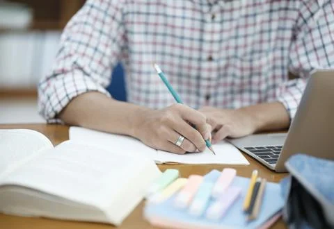 Student Taking Notes in Library with Laptop Stock Photos