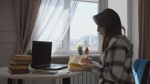 Student taking notes while studying on laptop at home Stock Footage 314611214
