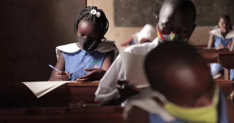 Student taking notes while wearing face mask due to the coronavirus emergency Stock Footage 146489812