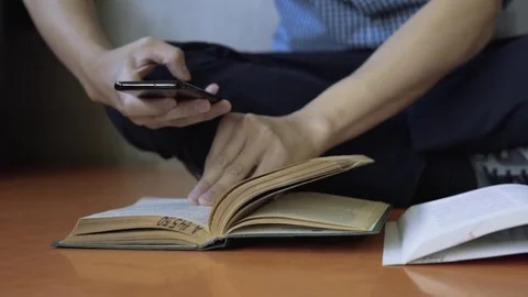 Student taking picture of book pages with smart phone. Coping notes. Cheating Stock Footage 80556427