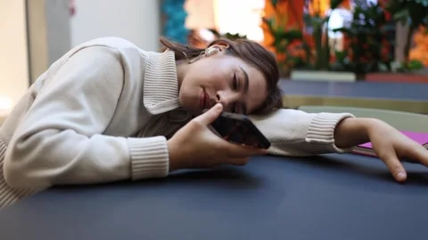 Student talks to artificial intelligence by voice while falling asleep in cafe Stock Footage 323738696