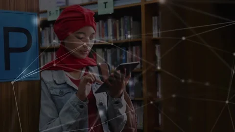 Student tapping tablet screen at library shelves and activating network overlay Stock Footage 319851474