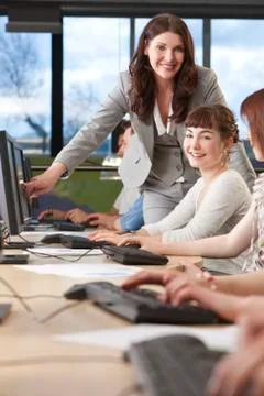Student &amp; teacher using computers at college Stock Photos