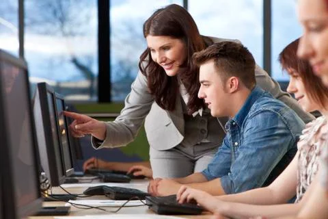 Student &amp; teacher using computers at college Stock Photos