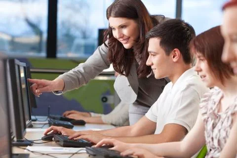 Student &amp; teacher using computers at college Stock Photos