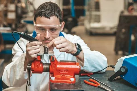 Student of technical school on practical exam when working with vise and Stock Photos