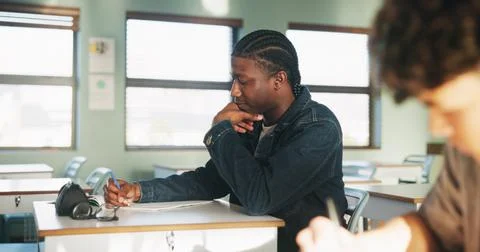 Student, thinking or writing in classroom with college assignment, education or Stockfoto's