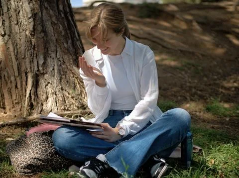 Student thinking over her notes under a tree Stock Photos