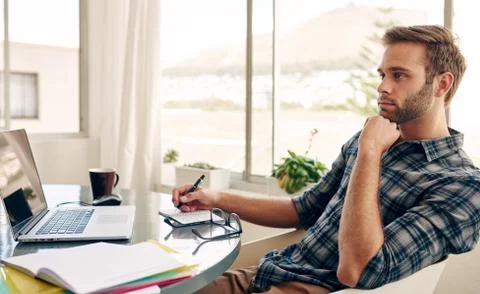 Student thinking while sitting at his desk Foto stock