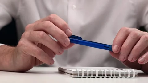 Student thoughtfully holds pen over notebook. simple hand gestures. closeup. Stock Footage 256076124