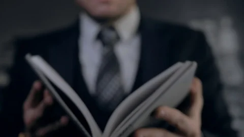 A student in a tie opens a textbook. A successful businessman opens a diary Stock Footage 89366670