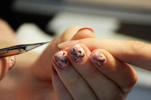 A student at the training courses of a manicure prepares the hand of a lady c Stock Photos