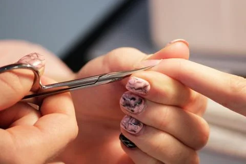 A student at the training courses of a manicure prepares the hand of a lady c Stock-Fotos