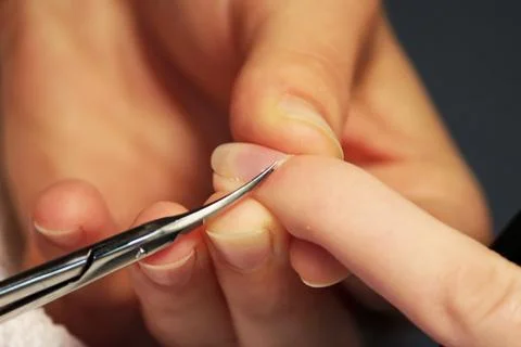 A student at the training courses of a manicure prepares the hand of a lady c Stock Photos