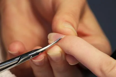 A student at the training courses of a manicure prepares the hand of a lady c Stock Photos