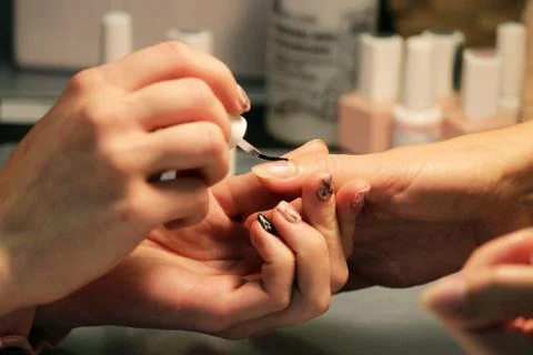 A student at the training courses of manicure prepares the hand of the client Stock Photos
