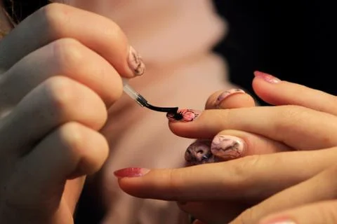 A student at the training courses of manicure prepares the hand of the client Stock Photos