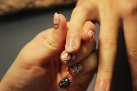 A student at the training courses of a manicure prepares the hand of a lady c Stock Photos