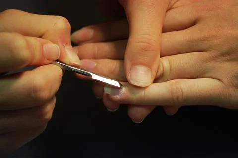 A student at the training courses of a manicure prepares the hand of a lady c Stock Photos