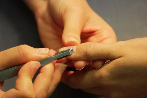 A student at the training courses of a manicure prepares the hand of a lady c Stock Photos